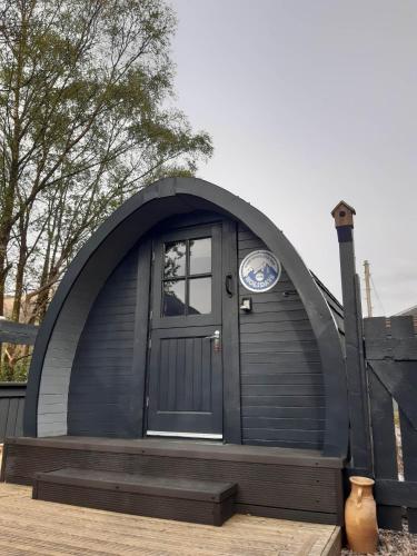 a dome shaped house with a door and a window at Nevis Pod, West Highland Way Holidays in Kinlochleven