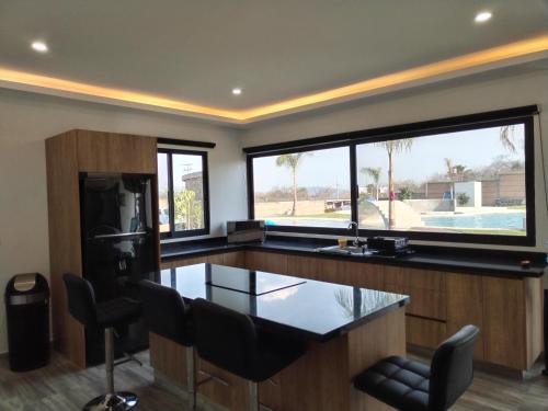 a kitchen with a counter and a large window at Quinta Gran Jardin in Tetecalita