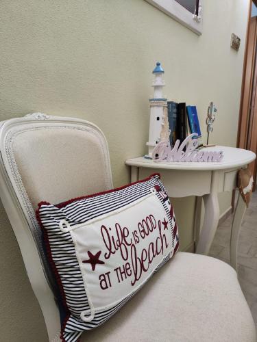 a pillow sitting on a chair next to a table at La Pirata Capitana in Costa degli Angeli