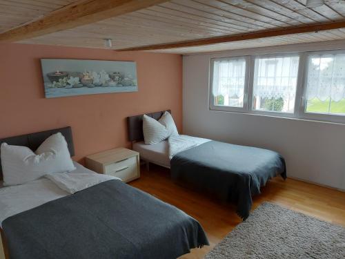 a room with two beds and a couch and windows at Bauernhaus Hinterbühle in Wolfhalden 