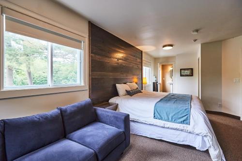 a bedroom with a bed and a couch and a window at 3 Pines Lodge Muskoka in Huntsville