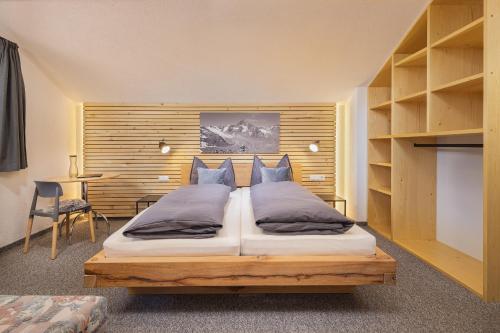 a bedroom with a large bed with a wooden headboard at Apart Bergzeit in Umhausen