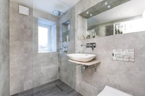 uma casa de banho com um lavatório e uma cabina de duche em vidro. em Luxury apartment in the centre of Winchester em Winchester