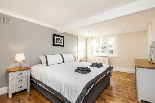 um quarto com uma grande cama branca e uma televisão em Luxury apartment in the centre of Winchester em Winchester