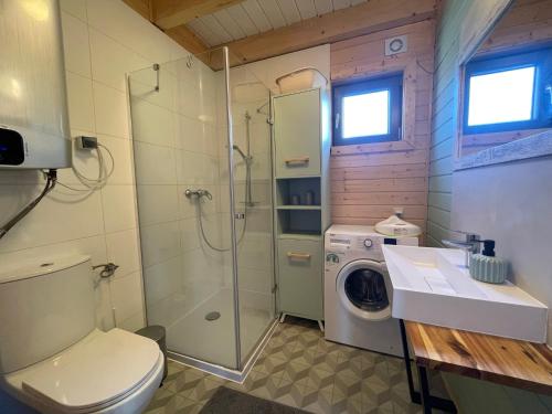 a bathroom with a shower toilet and a washing machine at Willa Arkadia Kopalino in Kopalino