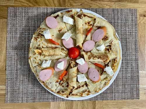 a pizza sitting on a plate on a table at GRAND JNK Boutique Hotel in Kukës