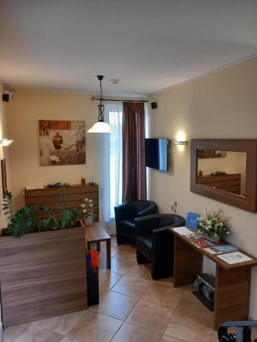 a living room with a couch and a table at Kata Panzió in Oroszlány