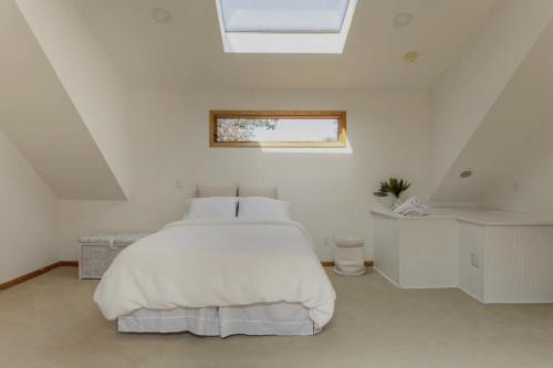 Habitación blanca con cama y ventana en Beachfront Mansion + Pool, 