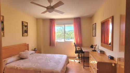 um quarto com uma cama, uma secretária e uma janela em Bungalow completo em Oropesa del Mar