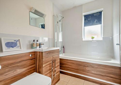 a bathroom with a tub and a toilet and a sink at Castaways Lodge 9 in Kessingland