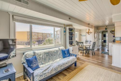a living room with a couch and a large window at Ocean-View Balcony Carolina Beach Condo! in Carolina Beach