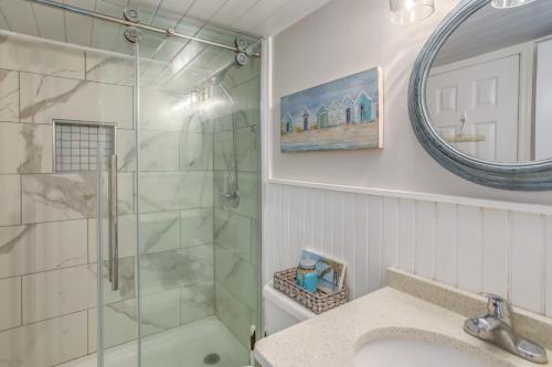 een badkamer met een douche, een wastafel en een spiegel bij Carolina Beach Condo with Community Pool in Carolina Beach