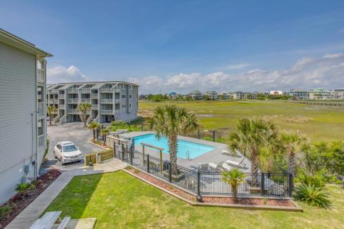 an aerial view of a resort with a pool and palm trees at Ocean-View Balcony Carolina Beach Condo! in Carolina Beach