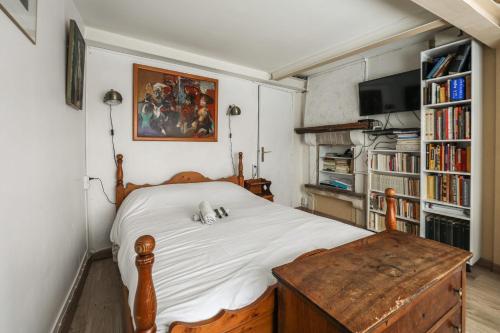 a bedroom with a bed and a table and bookshelves at Comfortable 1br in the 11th district of Paris - Welkeys in Paris