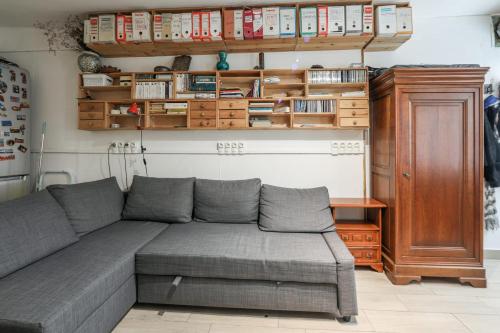 ein Wohnzimmer mit einem Sofa und einem Holzschrank in der Unterkunft Comfortable 1br in the 11th district of Paris - Welkeys in Paris