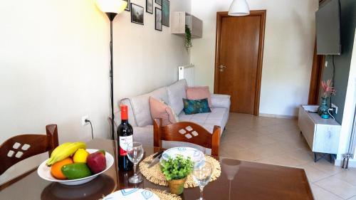 Magda's garden home. في Galatás: غرفة معيشة مع طاولة مع فاكهة وأريكة