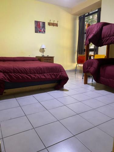 a bedroom with two beds and a tiled floor at Mitre Suites in Buenos Aires
