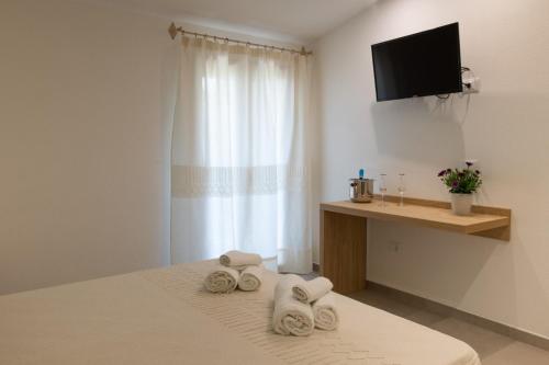 a hotel room with a bed with towels on it at Tarsis Guest House in Baunei