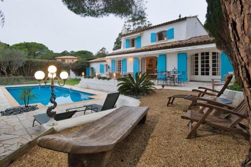 une arrière-cour avec un banc en bois et une maison dans l'établissement Villa Eleven StTropez Ramatuelle Pampelonne beach, à Saint-Tropez