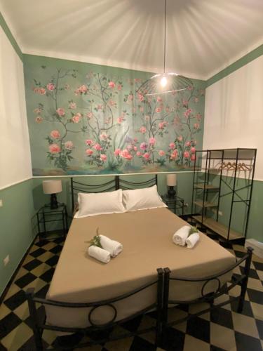 a bedroom with a bed with a floral wall at Blom apartments in Pisa