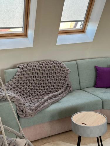 a green couch with a blanket on top of it at PANTELI APART HOUSE in Aheloy