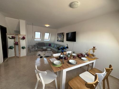 a living room with a table and white chairs at PANTELI APART HOUSE in Aheloy