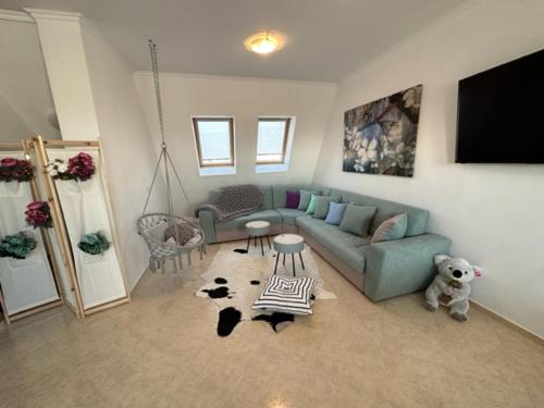 a living room with a blue couch and a tv at PANTELI APART HOUSE in Aheloy