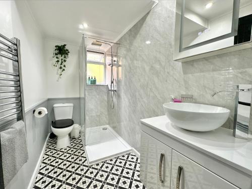 Baño blanco con lavabo y aseo en Cosy cottage with character., en Brixham