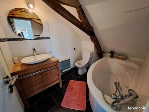 een badkamer met een bad, een wastafel en een toilet bij 24 Heures du Mans - GITE du Moulin du Breil in Écommoy