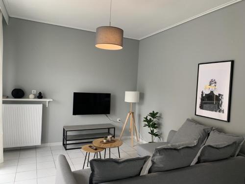 sala de estar con sofá y TV en White elephant second floor apartment, en Volos