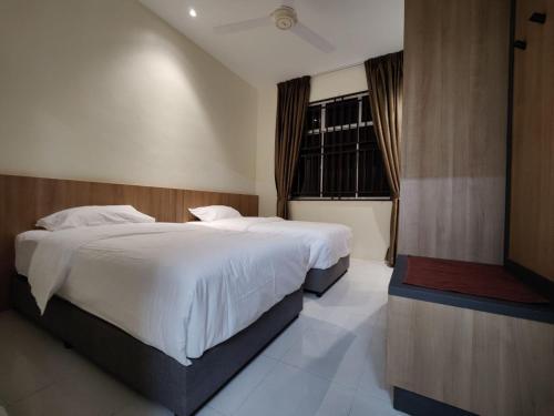 - une chambre avec 2 lits et une fenêtre dans l'établissement GEYI HOMESTAY, à Jerantut