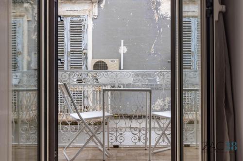 a glass door with a chair and a table on a balcony at ZAC 38 in Polignano a Mare