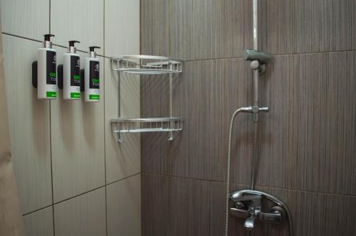 a bathroom with a shower with phones on the wall at Sunrise Apartments in Livadia
