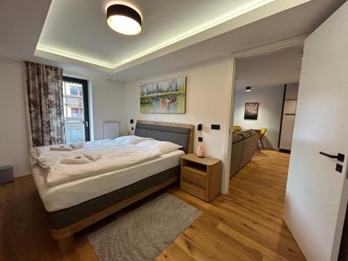 a bedroom with a large bed and a living room at Luxusní apartmán GRAND v centru Harrachova se saunou, wallboxem EV, parkováním zdarma, Netflix a HBO, velkým balkonem a výhledem na Čertovu horu ,sjezdovku a skokanské můstky in Harrachov