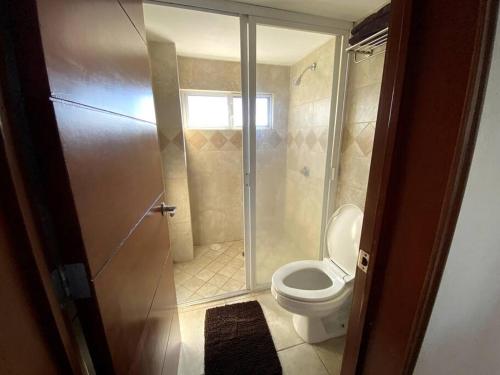 uma casa de banho com um WC e uma cabina de duche em vidro. em SUITE MISION JURIQUILLA #2 em Juriquilla