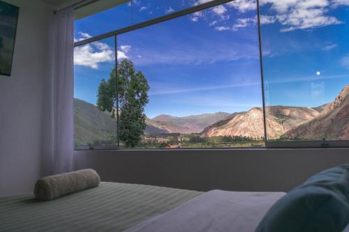 a bedroom with a large window with a view of mountains at Casa Yanahuara Valle Sagrado - Urubamba in Urubamba