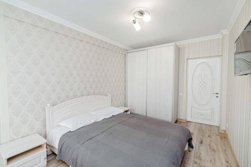Un dormitorio blanco con una cama grande. en Apartament cu vedere la parc, en Chişinău