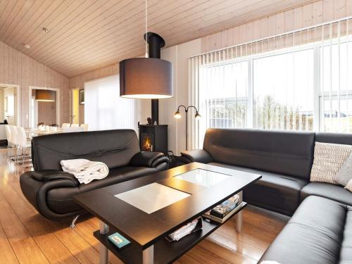 a living room with a black couch and a table at 6 person holiday home in Hirtshals in Hirtshals