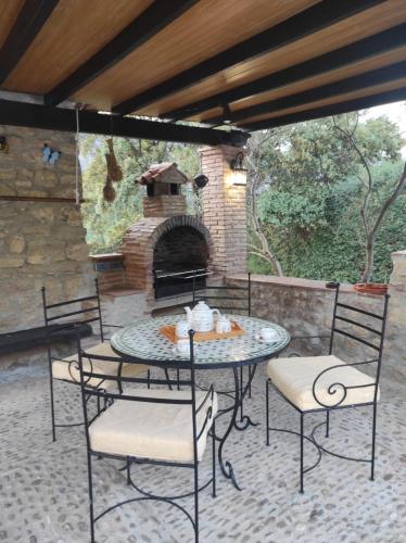 a patio with a table and chairs and a brick oven at Posada del Moral in Benaoján