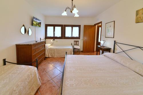 a bedroom with two beds and a dresser at Agriturismo Sasso Rosso in Capodacqua