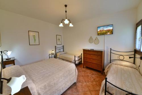 a bedroom with two beds and a dresser at Agriturismo Sasso Rosso in Capodacqua