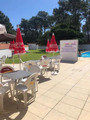 a group of tables and chairs with umbrellas at Rooms Cabedelo Beach Loft in Darque