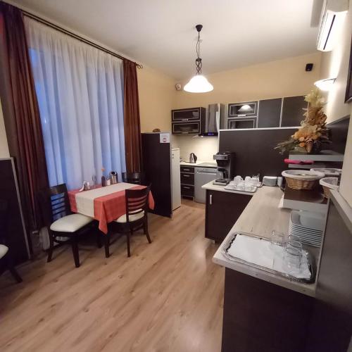 a kitchen with a table and a dining room at Kata Panzió in Oroszlány