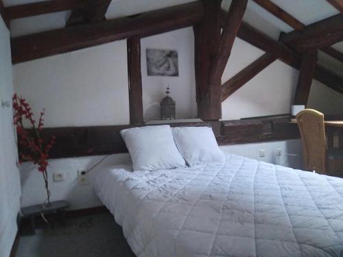 - une chambre avec un grand lit blanc et des plafonds en bois dans l'établissement Centre Sète, à Sète