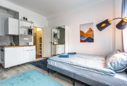 Biała sypialnia z łóżkiem i kuchnią w obiekcie ALLEE BUDA Apartment w Budapeszcie