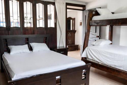 1 Schlafzimmer mit 2 Etagenbetten mit weißer Bettwäsche in der Unterkunft Espectacular casa de montaña in Pereira