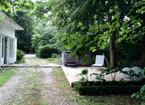 a patio with a chair and a tree at Magnifique villa golf du Touquet in Le Touquet-Paris-Plage