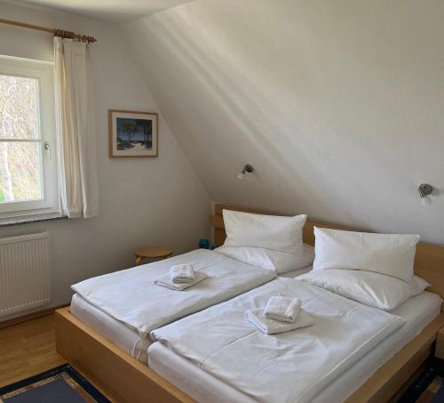 ein Schlafzimmer mit einem weißen Bett mit zwei Handtüchern darauf in der Unterkunft Ferienhaus Mine Sehnsucht in Dierhagen