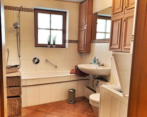 y baño con bañera, lavabo y aseo. en Ferienwohnung Kathi, en Samerberg