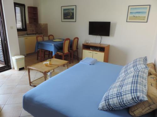 a room with a bed and a table and a kitchen at Apartmani Lavanda in Pag